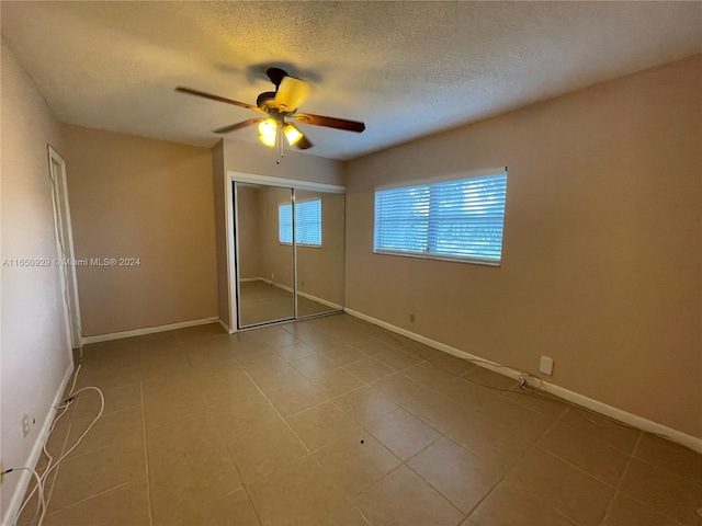 unfurnished bedroom with a closet, ceiling fan, and a textured ceiling