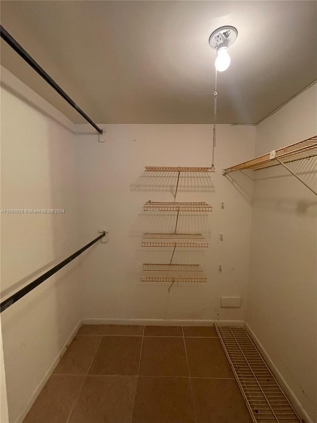 walk in closet featuring dark tile patterned floors