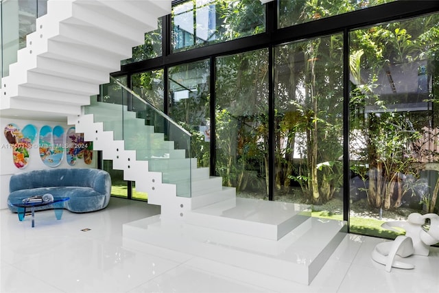 stairs with tile patterned floors and a wall of windows