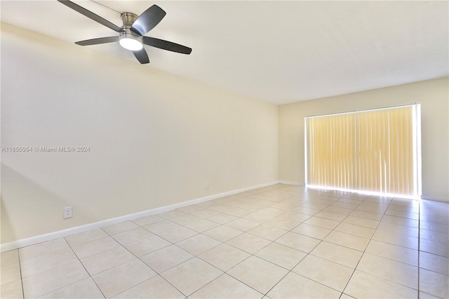 empty room featuring light tile patterned floors, baseboards, and ceiling fan