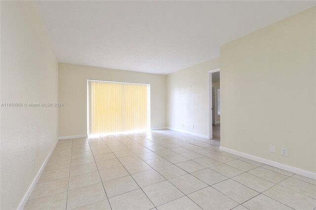 unfurnished room featuring light tile patterned flooring and baseboards