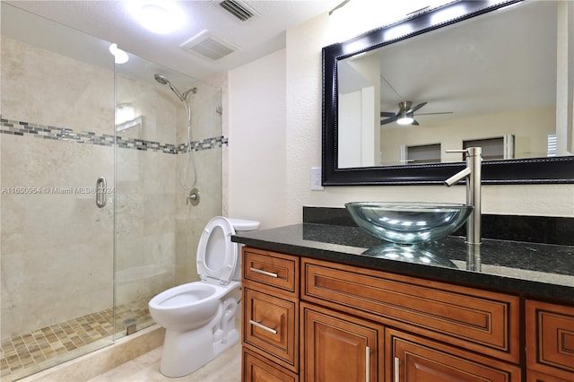 bathroom with vanity, toilet, walk in shower, and ceiling fan