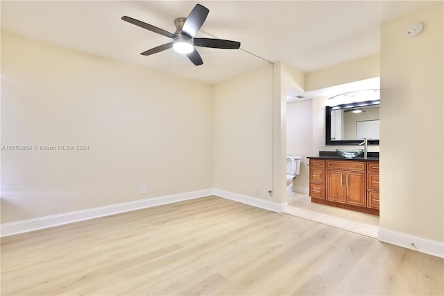 interior space with light wood-type flooring, sink, and ceiling fan