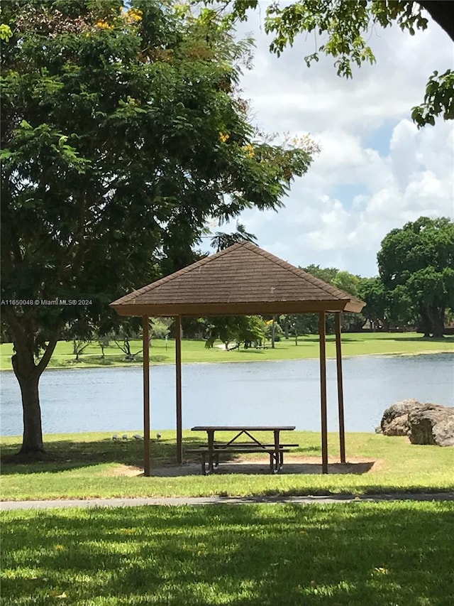 view of community featuring a water view, a lawn, and a gazebo