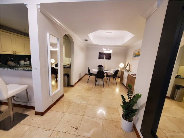 dining area featuring a raised ceiling and ornamental molding