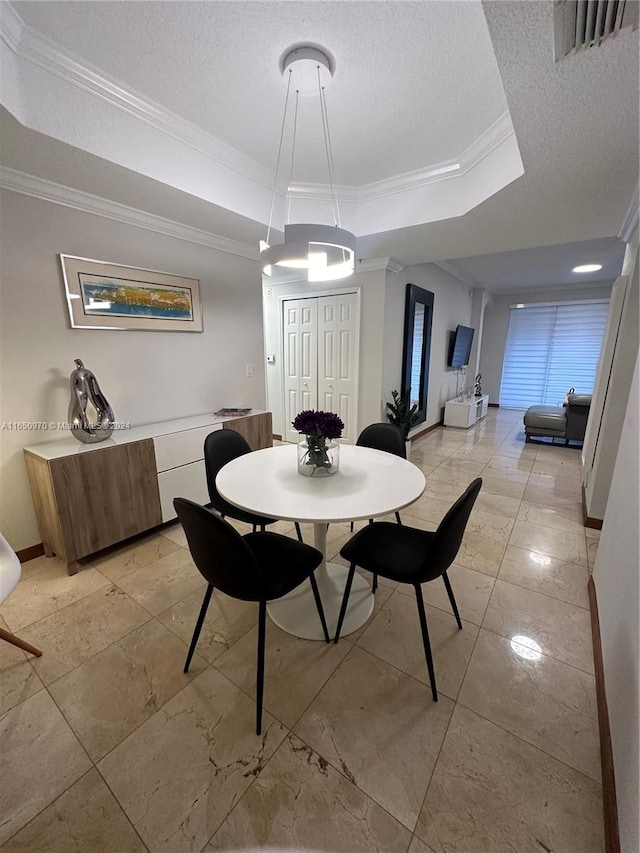 dining space featuring a tray ceiling, crown molding, and a textured ceiling