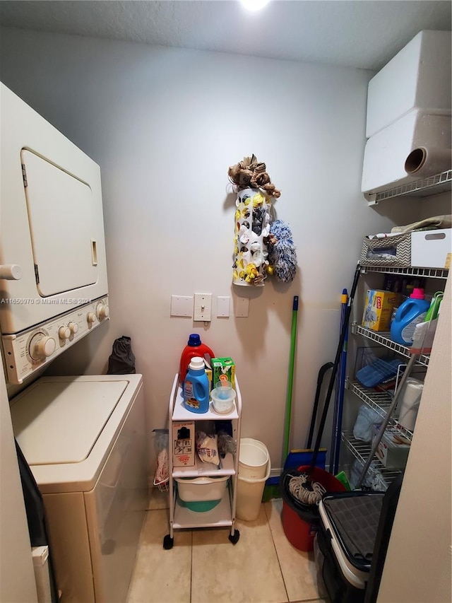 clothes washing area with light tile patterned floors and stacked washer and dryer