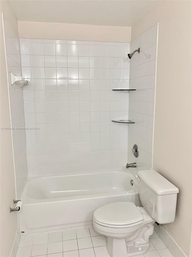 full bath with tile patterned floors, toilet, washtub / shower combination, and baseboards