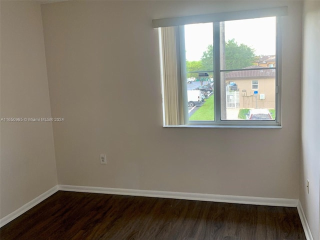 spare room with dark wood finished floors and baseboards