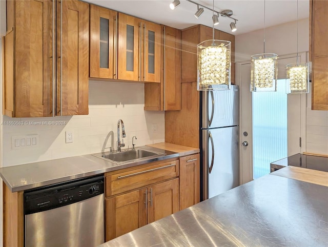 kitchen with stainless steel counters, hanging light fixtures, sink, and appliances with stainless steel finishes