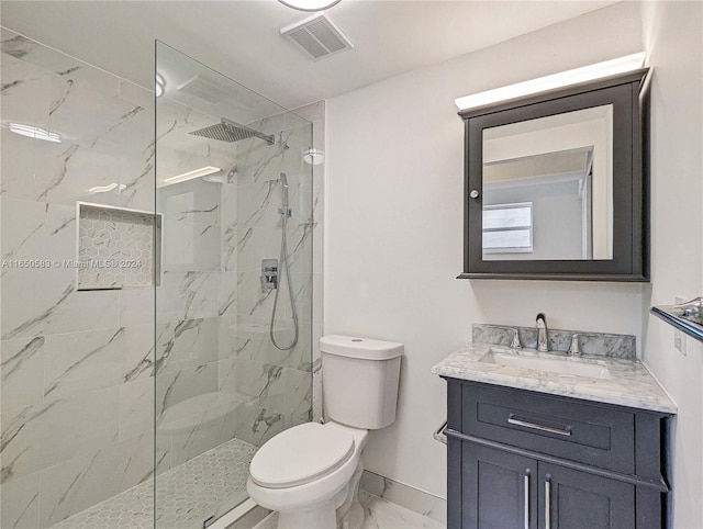 bathroom with vanity, toilet, and tiled shower