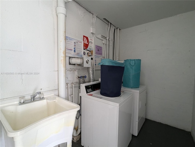 clothes washing area featuring separate washer and dryer and sink