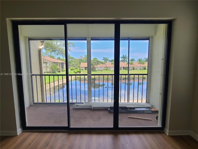 doorway to outside with a water view and hardwood / wood-style floors