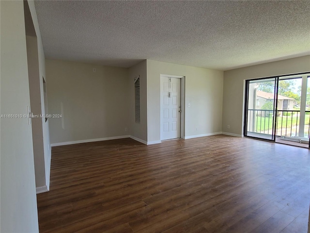 empty room with dark hardwood / wood-style flooring and a textured ceiling