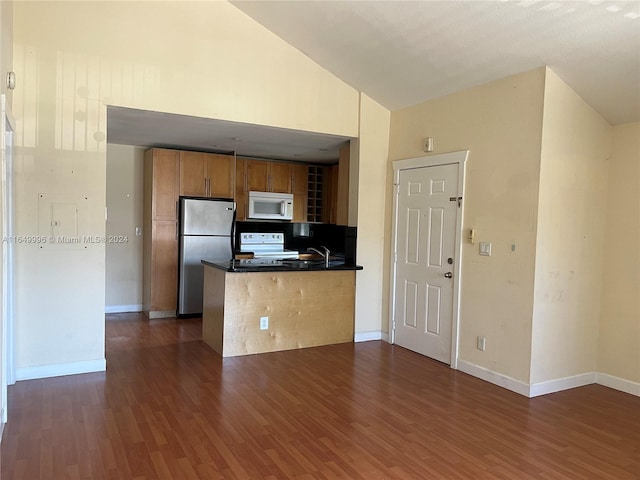 kitchen featuring white appliances, dark wood-type flooring, kitchen peninsula, sink, and high vaulted ceiling