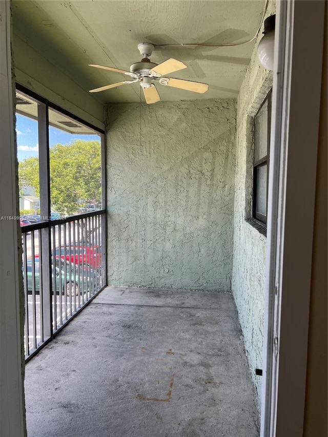 unfurnished sunroom featuring ceiling fan