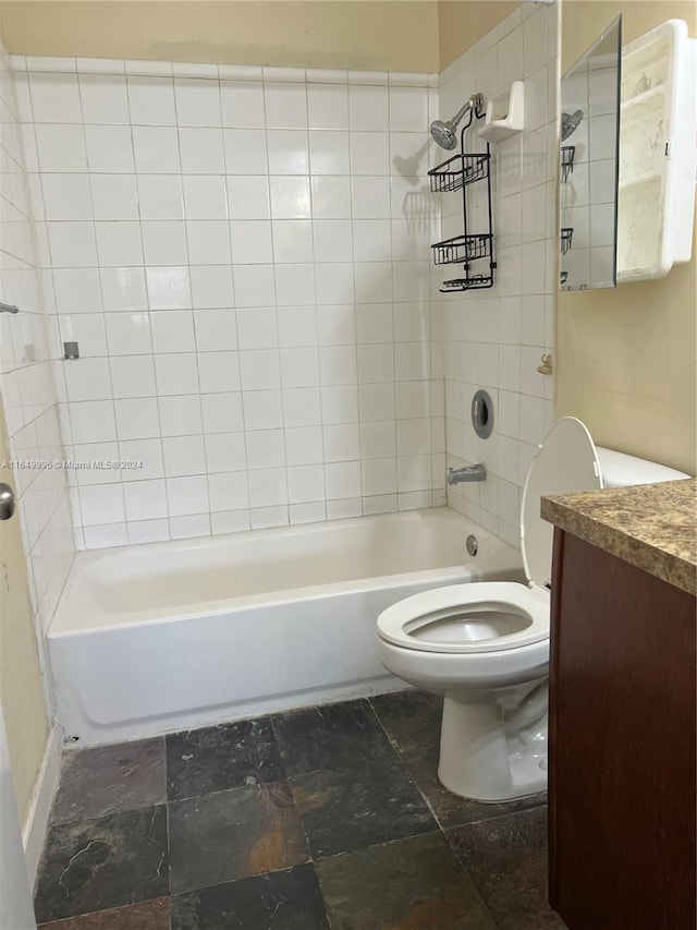 full bathroom with tiled shower / bath, toilet, and vanity