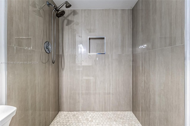 bathroom featuring toilet and tiled shower