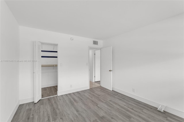 unfurnished bedroom with a closet and light wood-type flooring