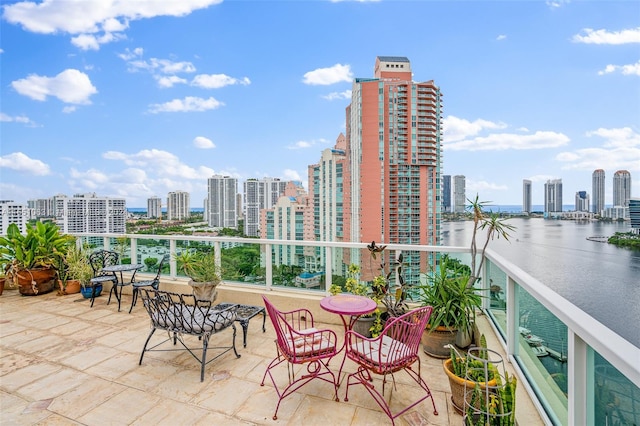 view of patio with a balcony and a water view