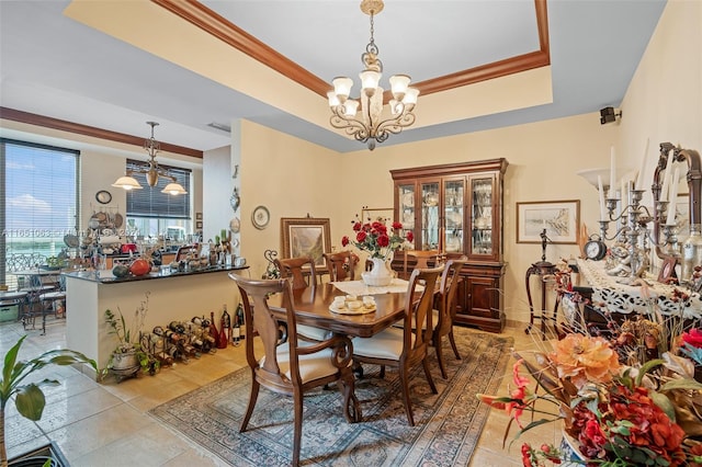 tiled dining room featuring crown molding, an inviting chandelier, and a tray ceiling