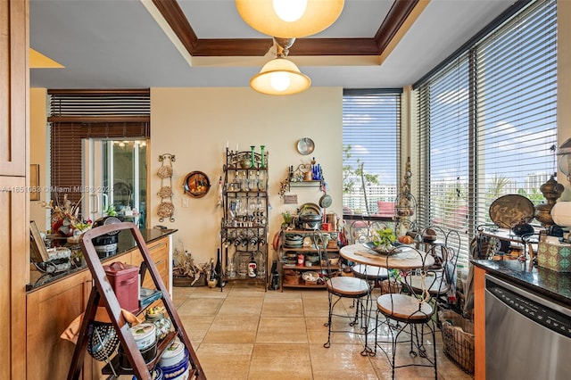 tiled dining room with crown molding and a raised ceiling