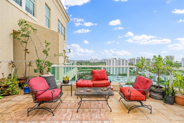 view of patio featuring a balcony and an outdoor living space with a fire pit