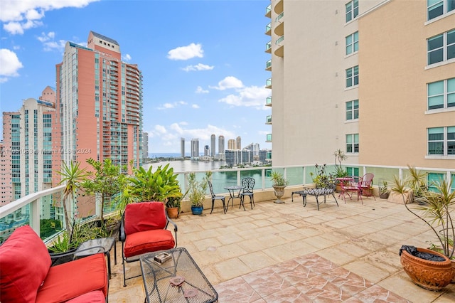 view of patio with a water view and a balcony