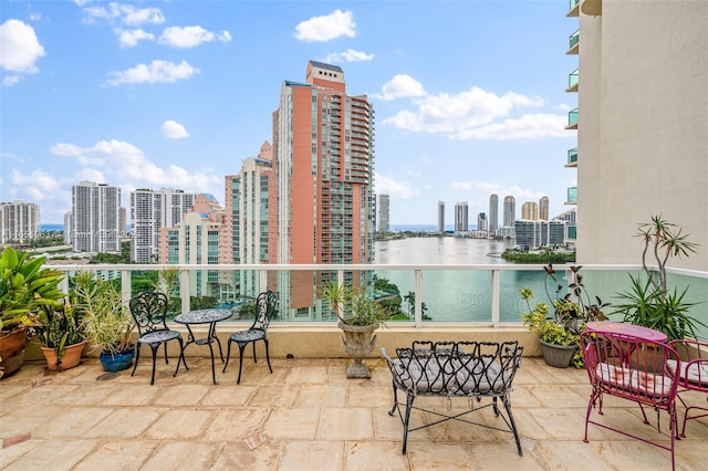 view of patio featuring a water view and a balcony