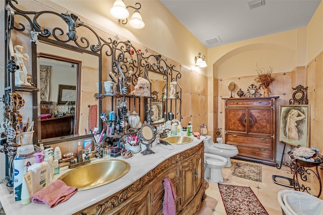 bathroom featuring tile patterned flooring, toilet, a bidet, and vanity