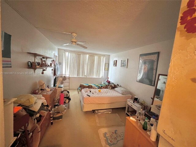 carpeted bedroom with a textured ceiling and ceiling fan