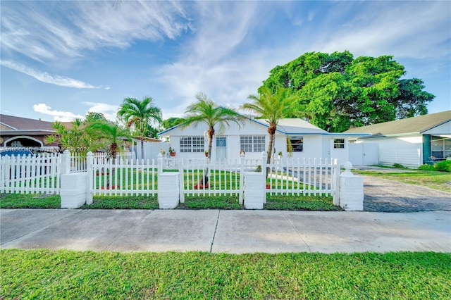 view of front facade with a fenced front yard and a front lawn