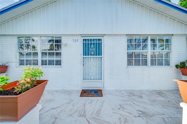 doorway to property featuring brick siding