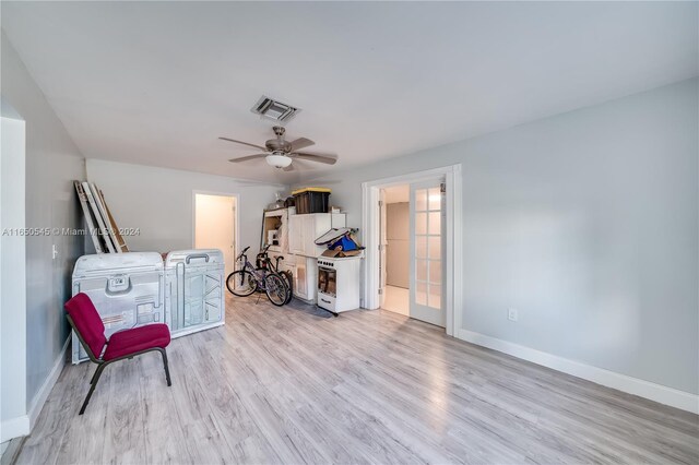 sitting room with light wood-type flooring, visible vents, ceiling fan, and baseboards