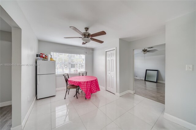 dining room with light tile patterned floors, baseboards, and a ceiling fan