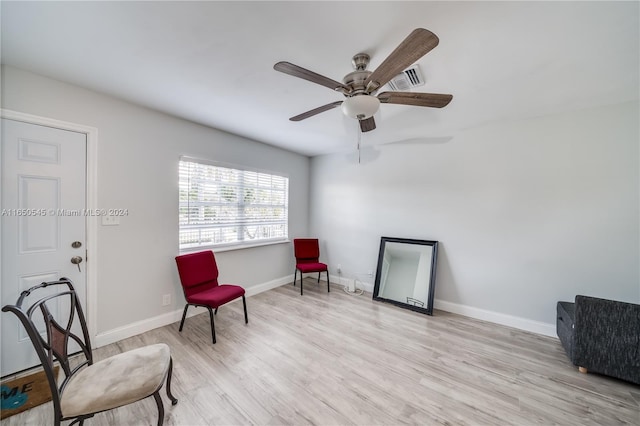 sitting room with ceiling fan, baseboards, and wood finished floors