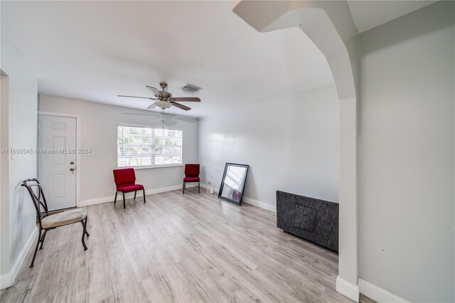 sitting room featuring light wood finished floors, ceiling fan, visible vents, and baseboards