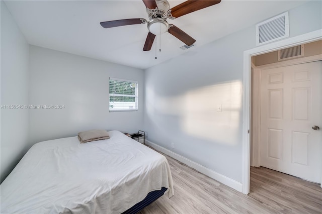 bedroom with baseboards, visible vents, and light wood finished floors