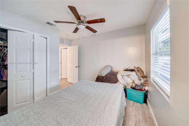 bedroom with a closet, ceiling fan, and light hardwood / wood-style flooring