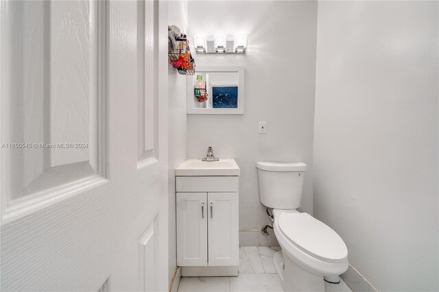 bathroom featuring marble finish floor, vanity, and toilet