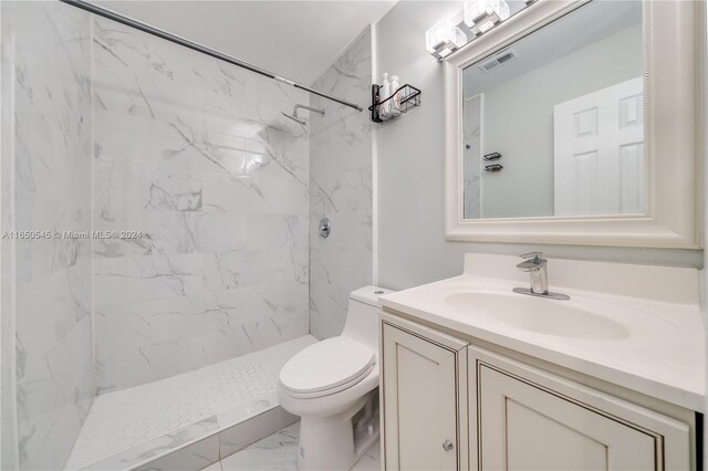 full bath with a marble finish shower, visible vents, toilet, marble finish floor, and vanity