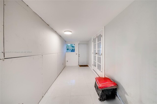 hallway featuring light tile patterned floors and french doors