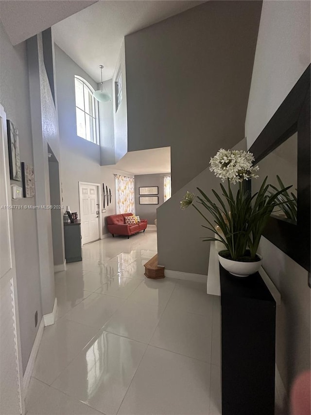 hallway featuring a high ceiling and tile patterned floors