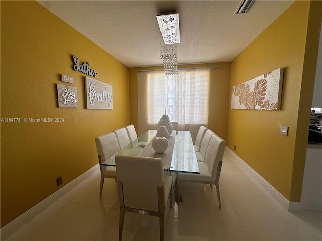 dining space with a textured ceiling and light tile patterned floors