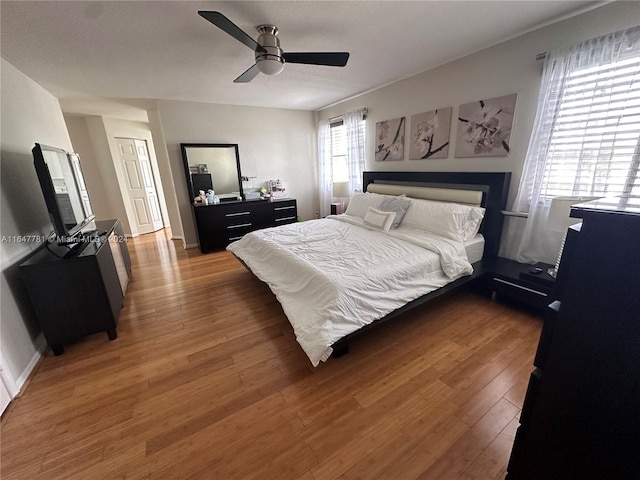 bedroom with a closet, ceiling fan, and dark hardwood / wood-style floors