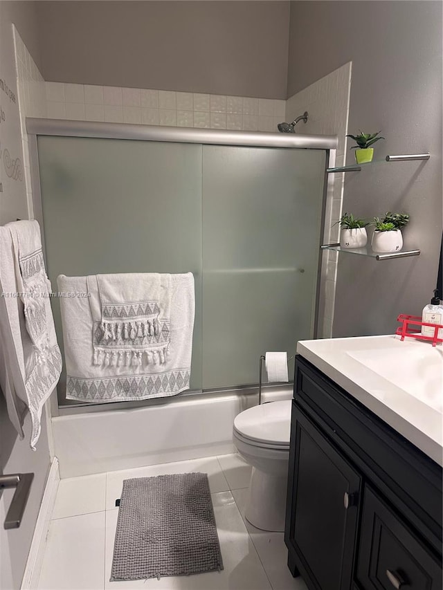 full bathroom featuring tile patterned flooring, enclosed tub / shower combo, toilet, and vanity