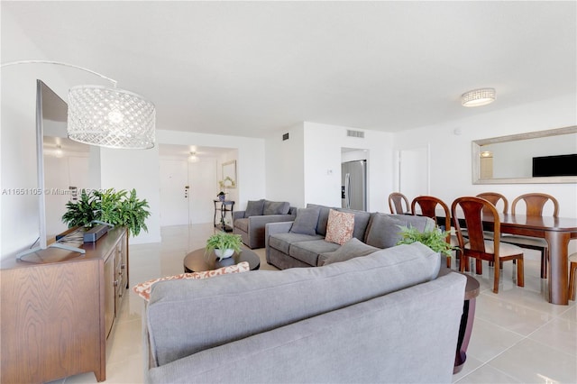 tiled living room featuring a notable chandelier