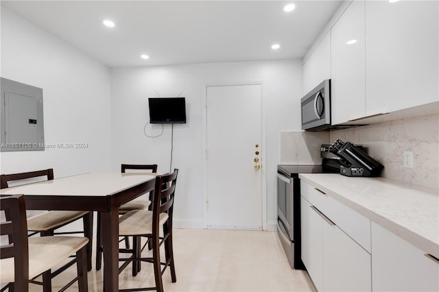 1080 94th St Unit 411, Bay Harbor Islands, FL 33154 - kitchen featuring stainless steel appliances, electric panel, recessed lighting, decorative backsplash, and white cabinets