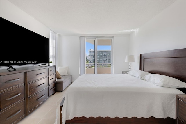 bedroom featuring a textured ceiling, access to outside, and light tile patterned flooring