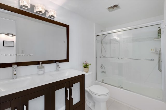 full bathroom with tile patterned flooring, vanity, toilet, and bath / shower combo with glass door